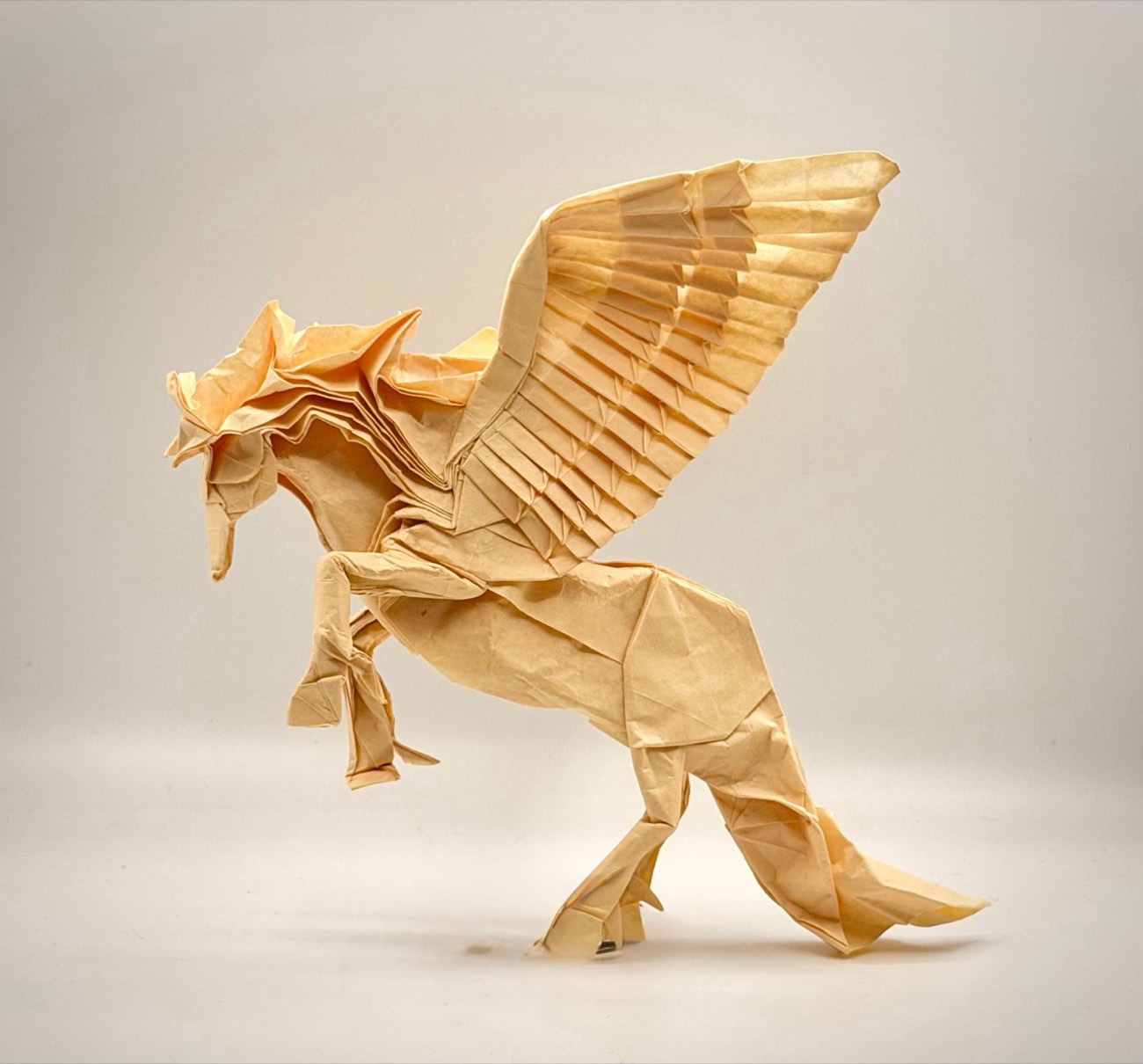 An intricate origami Pegasus with feathered wings